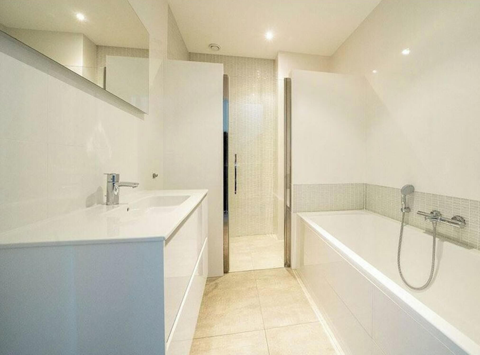 A modern bathroom with a large bathtub, a separate shower area, and a vanity with a sink.