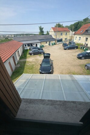 A residential area with multiple houses, a parking lot, and a car parked in the foreground.