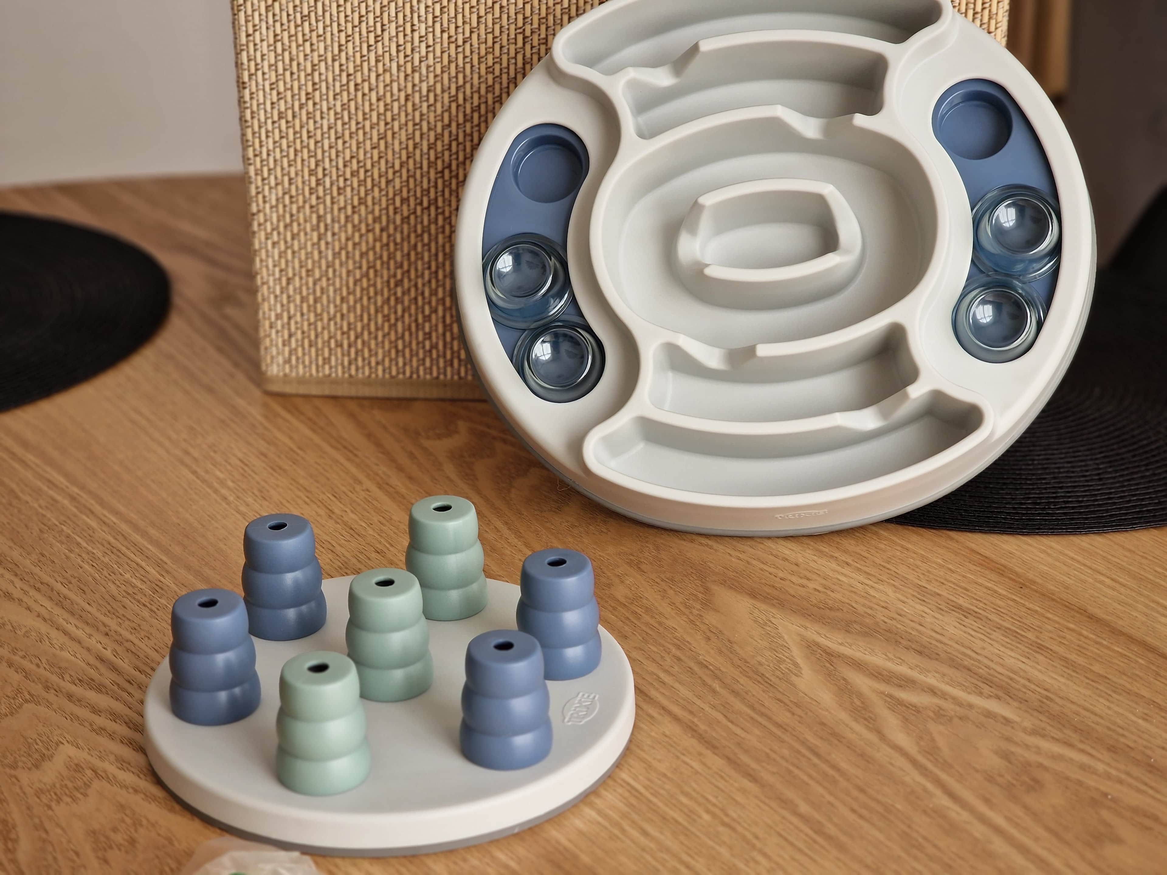 Un objet blanc doté de plusieurs compartiments et d’une base circulaire, accompagné de plusieurs objets cylindriques.
