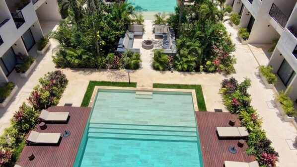 A rooftop pool area with a rectangular pool, surrounded by lounge chairs and greenery. - Family Pent-House with luxury amenities (Tulum)