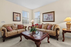 A living room with two sofas, a glass coffee table, and two lamps. - 4BR retreat w/ screened pool & spa (Davenport)