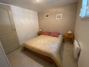 A bedroom with a bed, two bedside tables, a door, and two wall-mounted pictures. - South Ardeche: gite 2 bedrooms, air conditioning, wifi, swimming pool, Near Vallon Pont d'arc (Balazuc)