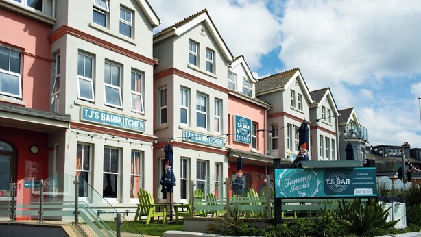 A row of buildings with signage for 'TJ's Bar & Kitchen' and 'TJ's Bar & Kitchen Entrance.' - Family King Room with Attached Single Room (Bude)