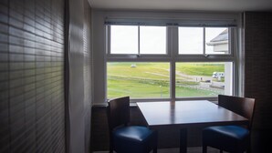 Una habitación con un ventanal grande, una mesa y dos sillas.