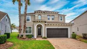 A two-story house with a garage, a driveway, and a well-maintained lawn. - The Yorkshire Grand Villa (Davenport)