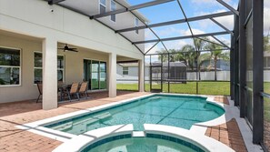A swimming pool with a covered patio area, a seating arrangement, and a view of the backyard. - The Yorkshire Grand Villa (Davenport)