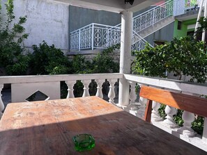 Ett träbord med en grön glasskiva ovanpå, en vit balustrad och en trappa med vita räcken.