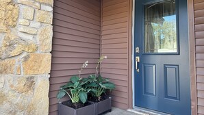 A house with a stone exterior, a blue door, and a planter with plants. - LuxModern Sparkling Clean 3BR 2BA by Ft. Hood-King Bed-MassageChair-PetFriendly! (Copperas Cove)