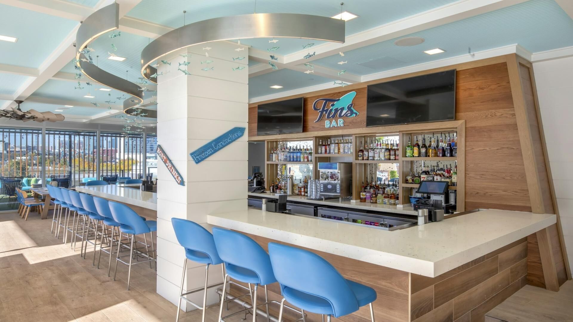 A bar area with a counter, bar stools, and a variety of bottles.