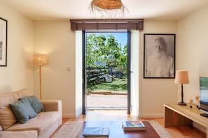 A living room with a sofa, a coffee table, a lamp, and a television. - VIVA Countryside Escape Minho (Caminha)