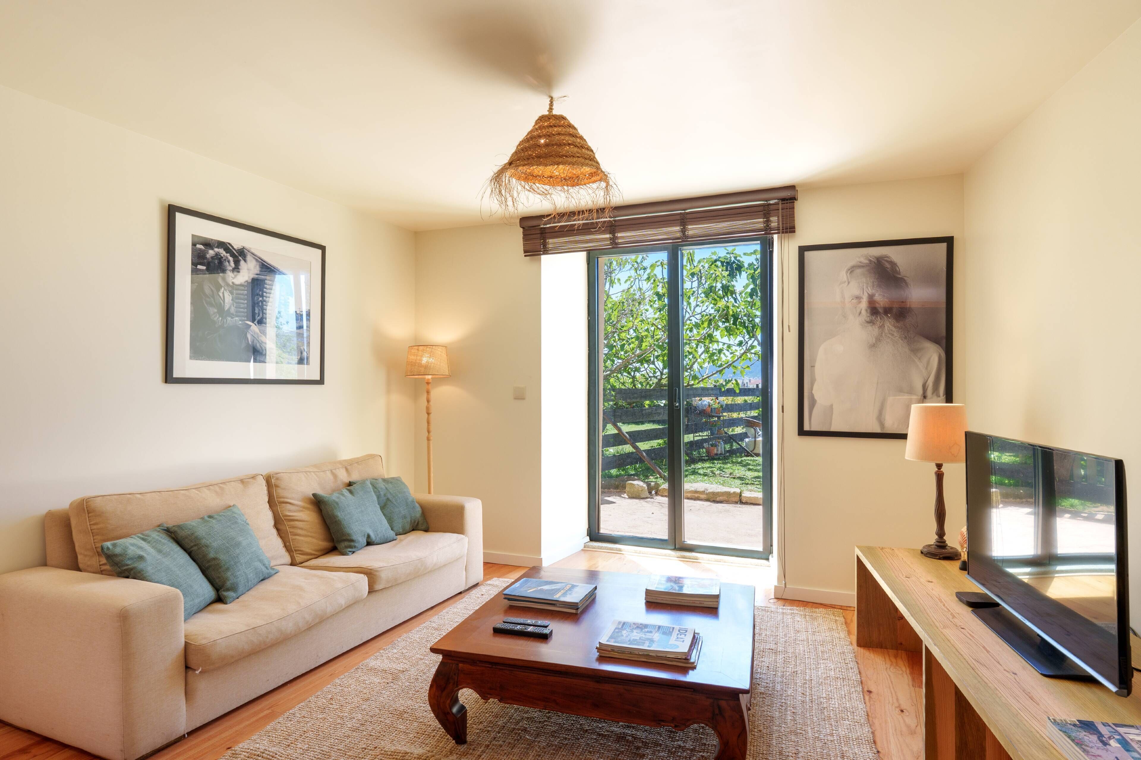 A living room with a sofa, coffee table, and a television.