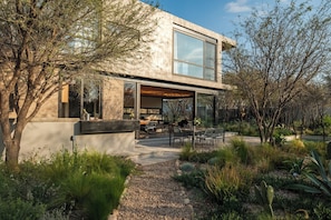 Une maison moderne dotĂ©e dâun patio, dâun espace salon extĂ©rieur et dâun jardin.