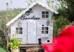 Un bâtiment blanc sur lequel on peut lire le mot « Caméléon » sur la façade, les fenêtres et les lanternes.