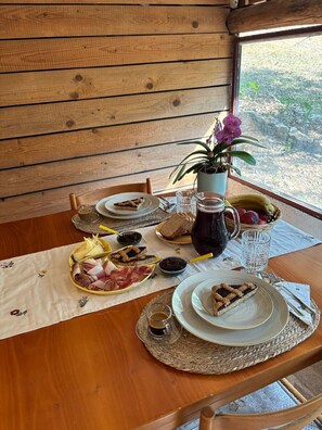A wooden table with plates of food, a pitcher, and a potted plant. - Cozy house in the Chianti region (Toscana)