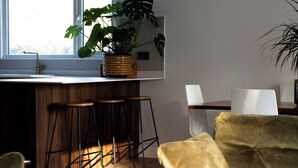 A modern kitchen with a bar area, a large window, and a sofa.