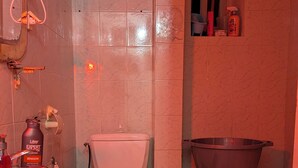 Ett litet badrum med ett vitt handfat, en toalett och en tvättställ.