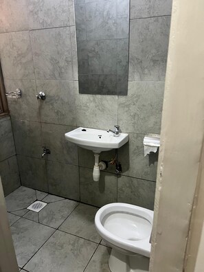 Ein Badezimmer mit einem weißen Waschbecken, einer Toilette und einer Duschkabine.