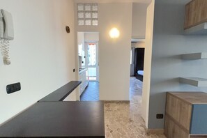 A hallway leading to a kitchen with a countertop and a door to another room. - 5 Minuten zu Fuß vom Bahnhof Milano Lambrate (Milan)