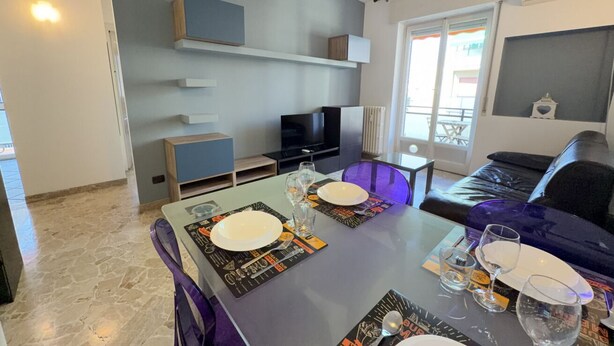 A dining area with a table set for two, a television, and a sofa in a modern living space. - 5 Minuten zu Fuß vom Bahnhof Milano Lambrate (Milan)