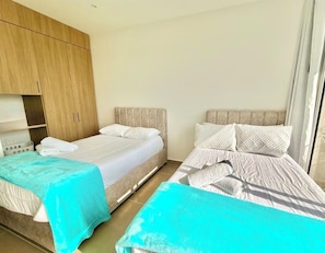 A hotel room with two beds, a wooden wardrobe, and a window with curtains. - Kristal lagoon apartment baia cristal (Bolívar)