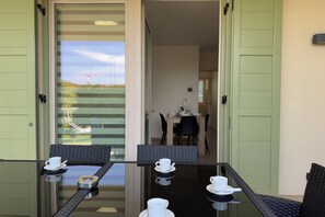 A dining area with a glass table, chairs, and white cups. - 20 min from Gardaland and lake with swimming pool (Valeggio sul Mincio)