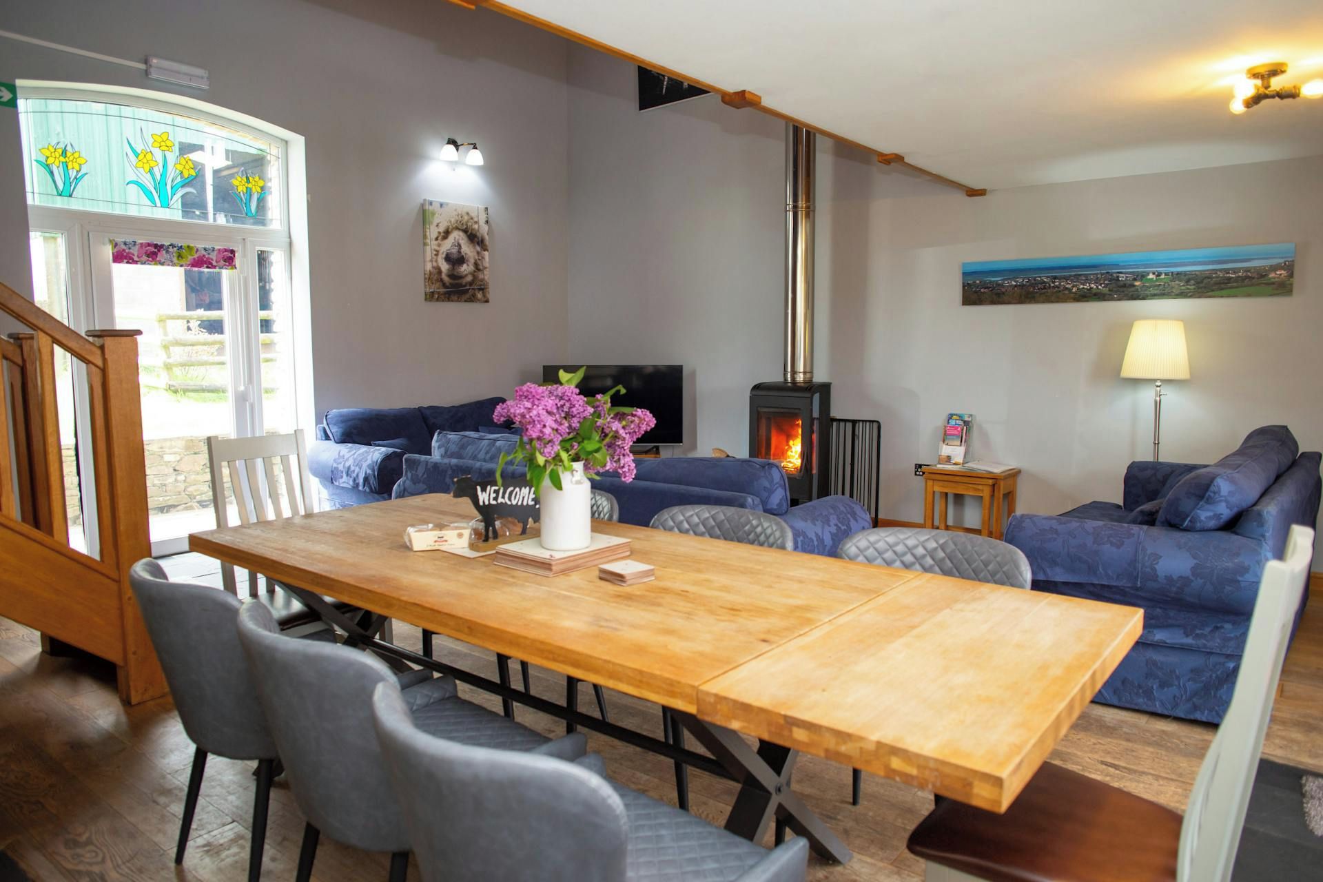 Ein gemütliches Wohnzimmer mit Kamin, Esstisch und einer Couch.