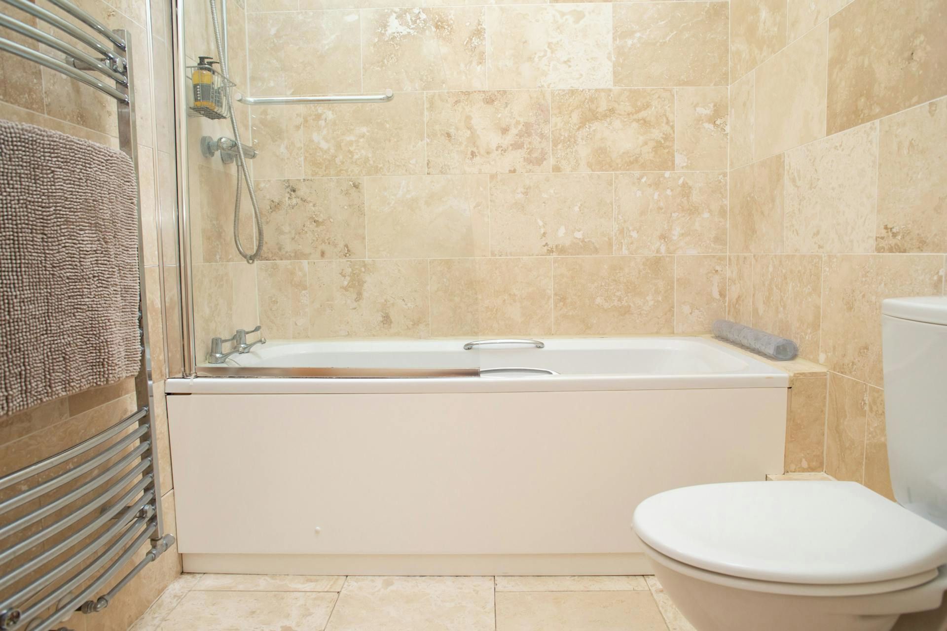 A bathroom with a bathtub, toilet, and shower.