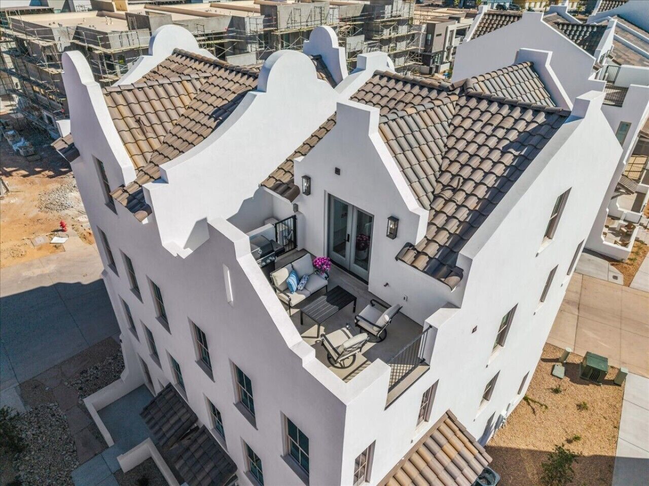 Een meerlaags gebouw met een dakterras, balkons en een moderne architectuur.