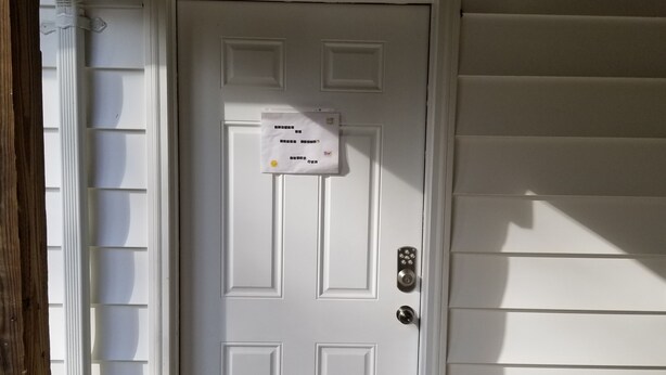 A white door with a sign, a mailbox, and a mailbox slot. - Cozy 1-bedroom apartment in  Bethesda (Bethesda)