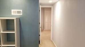 A hallway with a white shelving unit, a vent on the wall, and a door leading to another room. - Cozy 1-bedroom apartment in  Bethesda (Bethesda)