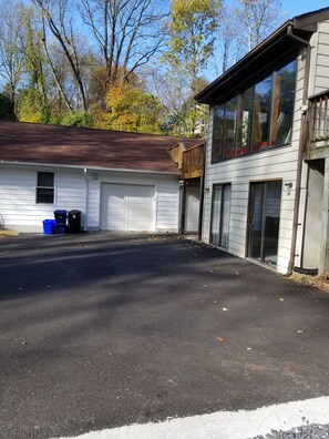 A two-story building with a garage, a covered porch, and a driveway.
