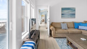 Una habitación con sofá, mesa de centro, televisor y ventana.
