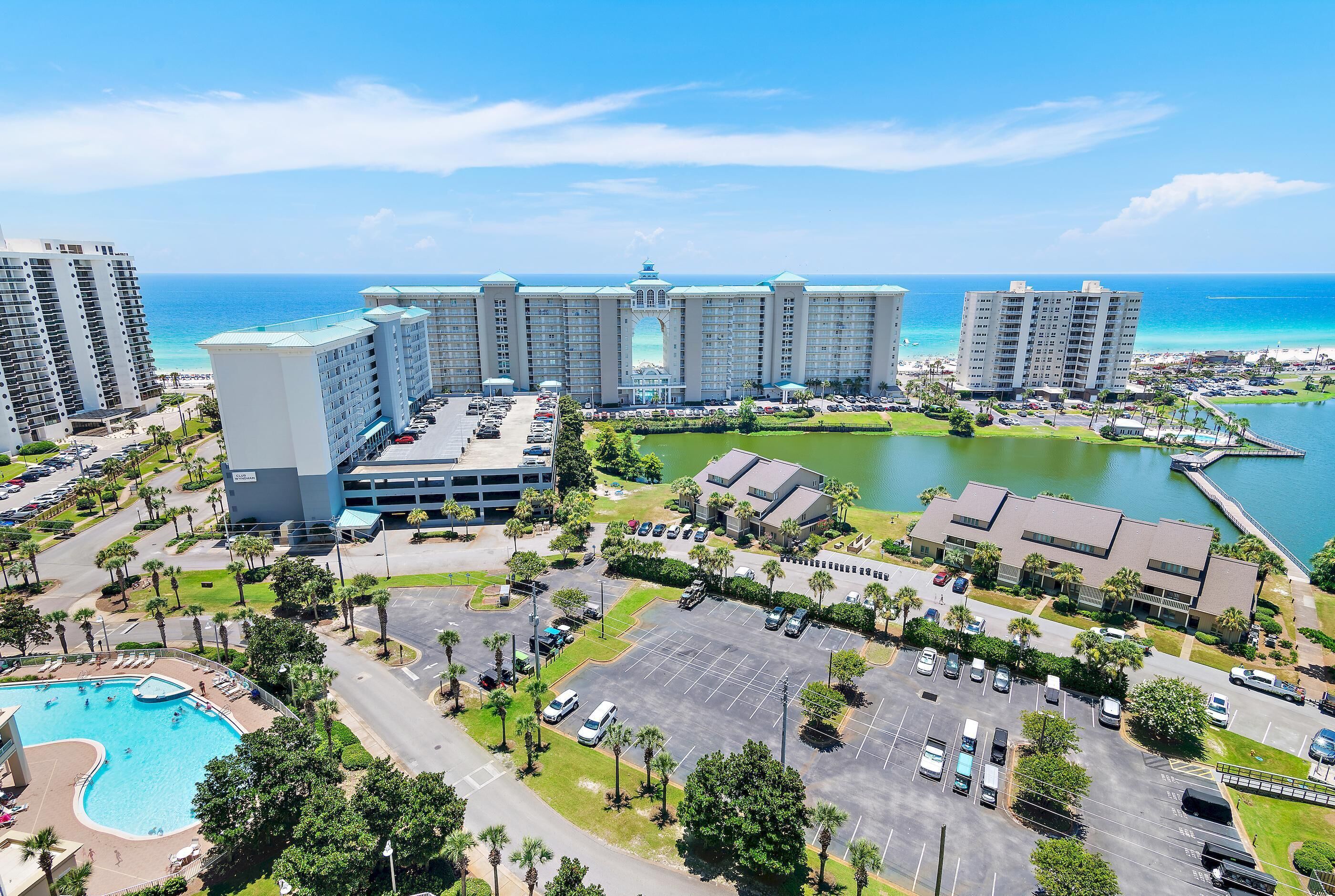 A large hotel complex with multiple buildings, a parking lot, and a swimming pool.