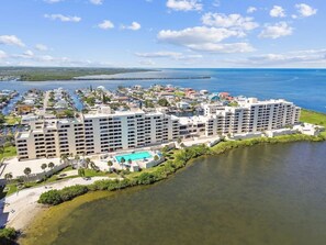 Ein Hotel an der Küste mit mehreren Gebäuden, einem Pool und einem Yachthafen.