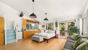 Ein modernes Schlafzimmer mit Bett, Sofa und Essbereich.