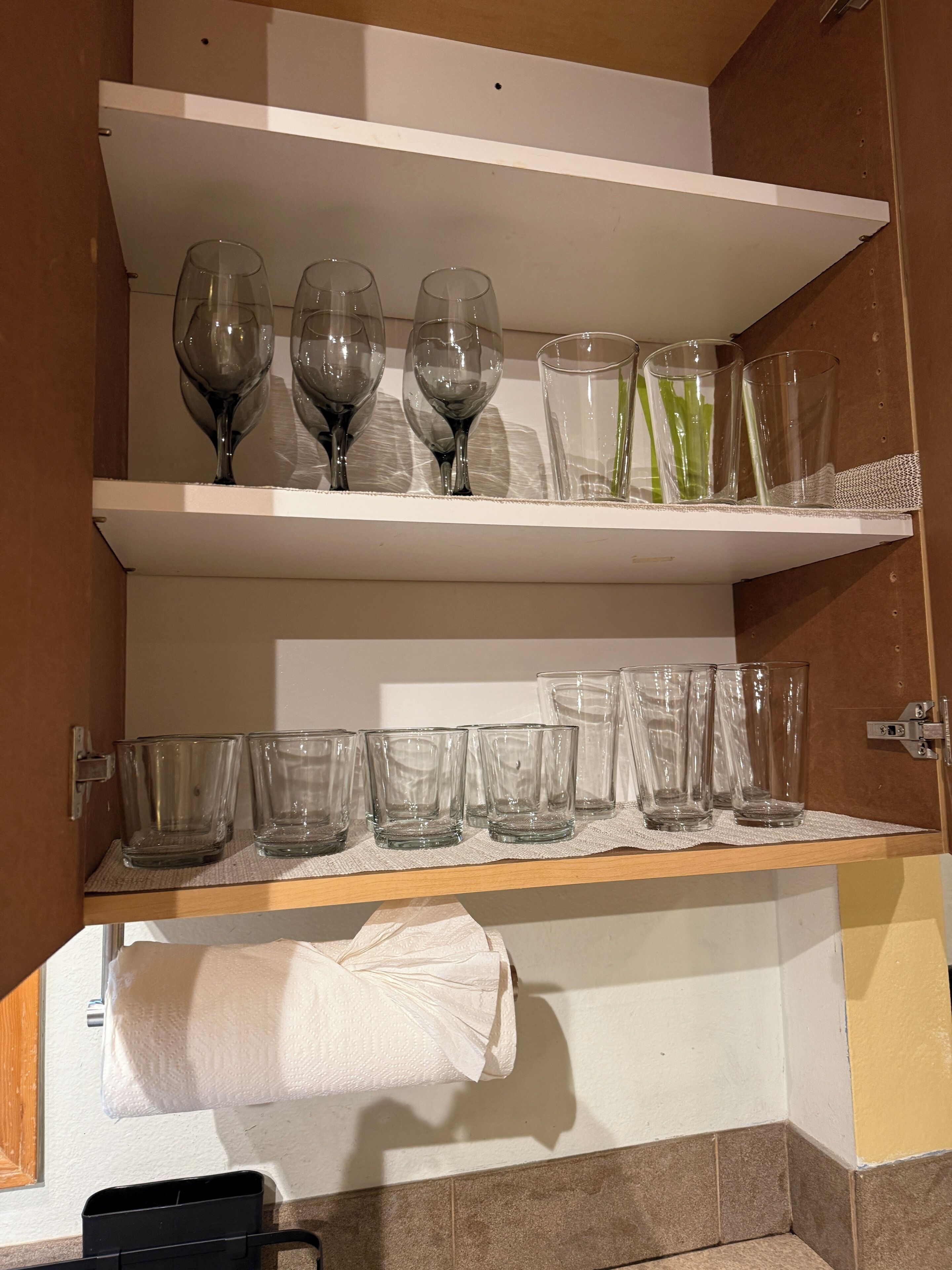 Et badeværelse med et håndklædestativ, en hylde med vinglas og en hylde med klare glas.