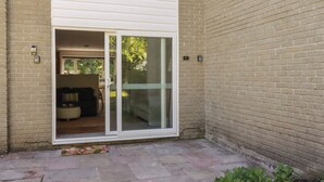 A residential building with a sliding glass door leading to a patio area. - 67 Manor Villas (St. Columb Major)