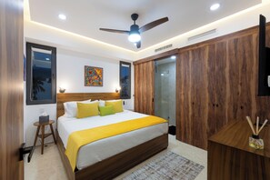 A modern bedroom with a bed, bedside table, ceiling fan, and a wooden wardrobe. - Condo Zona Romantica a block away from the beach. (Puerto Vallarta)