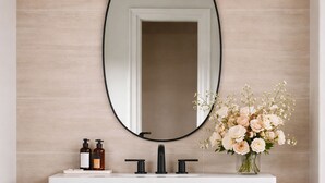 Un baño con un espejo grande, un lavabo blanco y dos botellas de jabón.