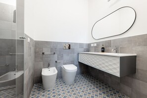 A modern bathroom with a glass shower enclosure, a bidet, a toilet, and a vanity with a mirror. - 8 Min walk from the Station, Designer Studio Flat (Milan)