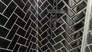 A shower area with black tiled walls and a visible showerhead. - Room-makays Guests House Kimberley (Kimberley)