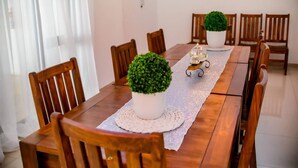 A dining table with chairs, a potted plant, and candles. - Room-makays Guests House Kimberley (Kimberley)