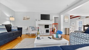 Una sala de estar moderna con chimenea, televisor y comedor.