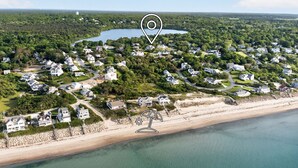 Vista aérea de una zona residencial costera con casas, una playa y un lago.