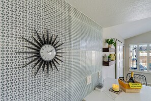 A modern kitchen with a unique geometric backsplash, a sunburst clock, and a welcoming note on the counter. - Beautiful Mid Century Modern 2/2 with resort style backyard in Sun City West (Sun City West)
