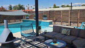 Ein überdachter Außenbereich mit Pool, Grill und Blick auf die umliegende Landschaft.