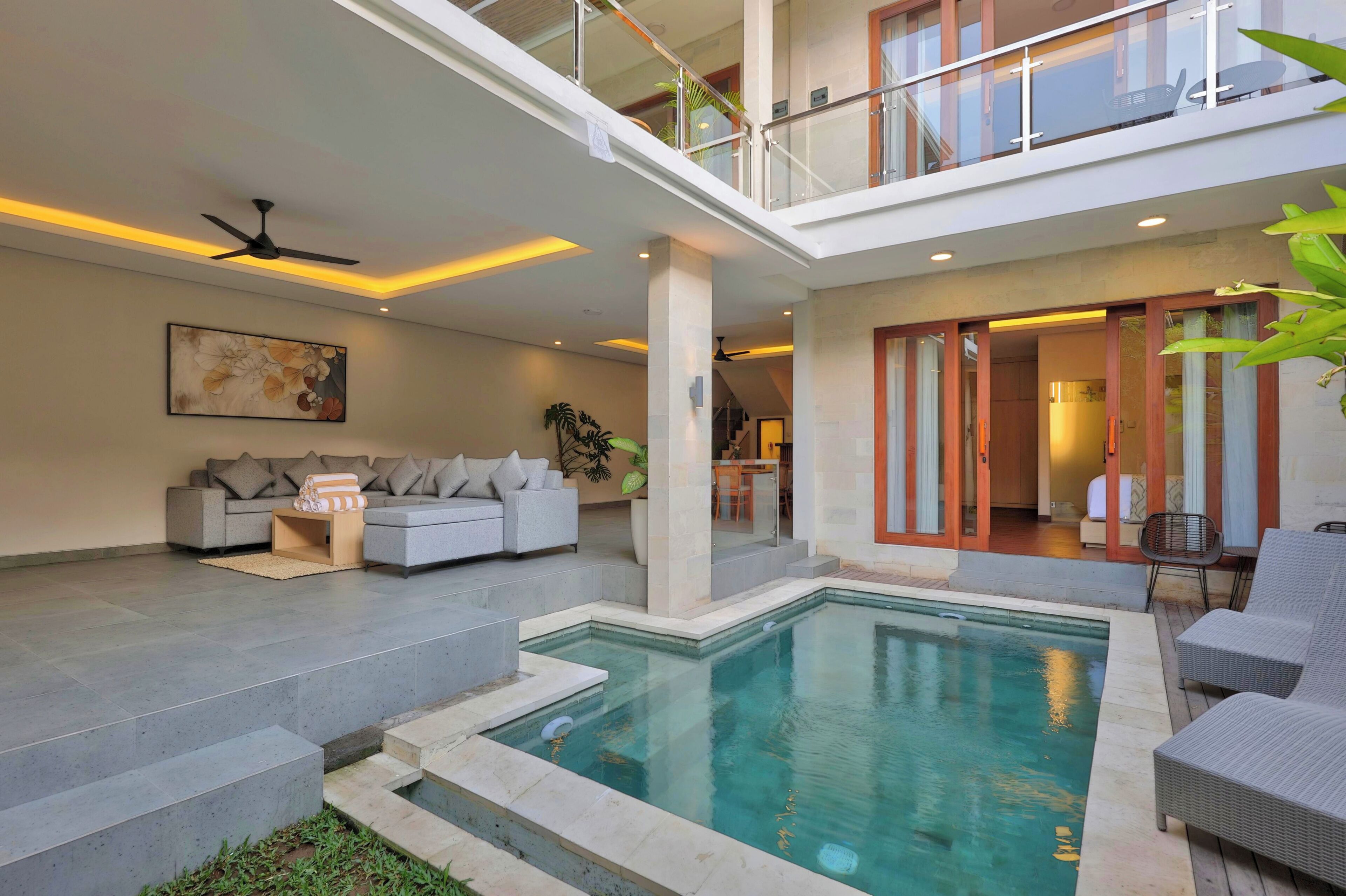 A modern living area with a pool, a sofa set, and a dining area.