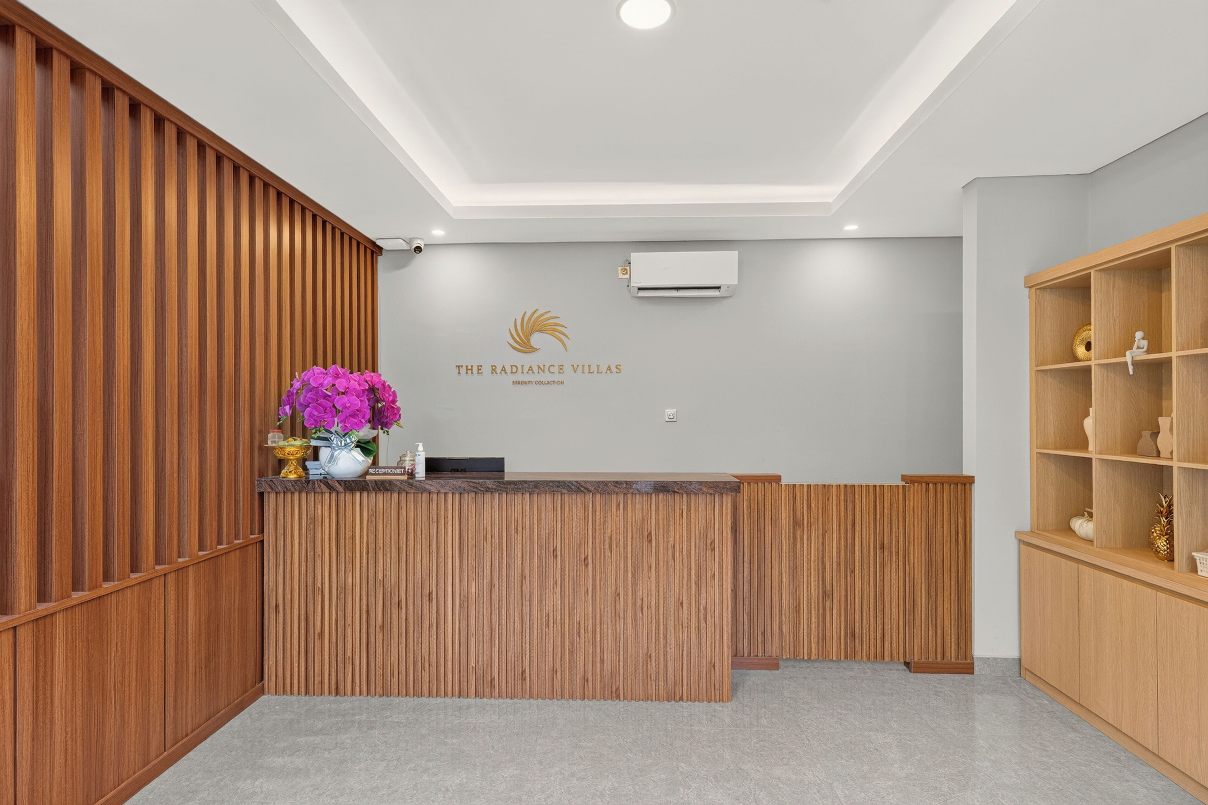 Una recepción con revestimiento de madera, un logotipo en la parte superior y una estantería con adornos.