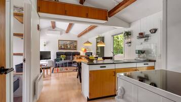 Une cuisine moderne avec des meubles en bois, un îlot central et un coin repas comprenant un canapé et une table.