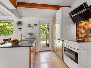 Eine moderne Küche mit Einbauofen, Kaffeemaschine und großem Fenster.